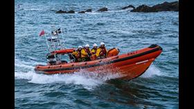 Looe RNLI’s Atlantic 85 returning to station on Sunday evening, with Jonty, on seat 4, waving