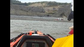 Barry Dock RNLI inshore lifeboat on scene with Rescue 187 band the Coastgurad Rescue Team who are on the shore