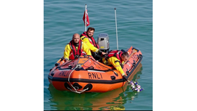 A member of the inshore lifeboat crew lays a wreath on the sea