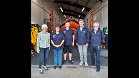 The visitors with RNLI volunteers with the inshore lifeboat James and Helen Mason