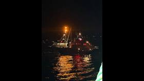 Picture shows a lifeboat alongside a fishing vessel