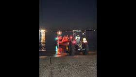a picture of an Atlantic 85 B Class lifeboat being recovered from the water by a tractor and trailer unit in darkness