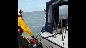 Lifeboat moored next to the casualty vessel using a mechanical pump to remove water from rear compartment