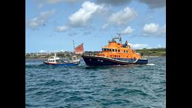 Picture shows a lifeboat towing a fishing boat