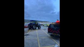 Boathouse forecourt with New Holland tractor, Coastguard truck and police car