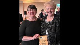 Two women with an award.