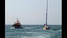 Skegness Shannon class lifeboat and yacht feeling fantastic on open water yacht under tow by Wells RNLI blue skies