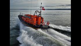 Seahouses RNLI all weather lifeboat at sea with waves breaking behind the lifeboat