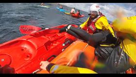 RNLI crews pulling a paddleboarder onboard the lifeboat
