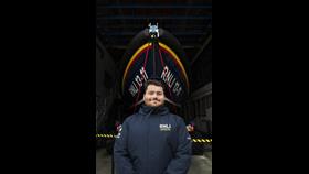A face-to-face fundraiser standing in front of a Shannon Class lifeboat