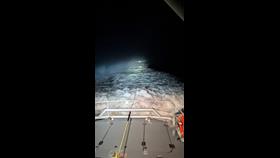 Photo taken to the aft of the George Sullivan, showing the casualty under tow. The casualty is distant and the photo taken at night, so the frame is mainly showing the all-weather lifeboat wake.