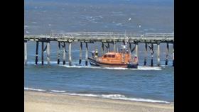 Lowestoft RNLI Lifeboat rescuing a paddle boarder