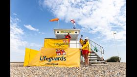 RNLI lifeguards setting up a beach lifeguard unit