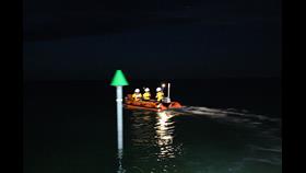Wells inshore lifeboat Peter Wilcox assists two casualties cut off by the tide launchingin the dark with three volunteers green buoy in the forground