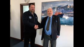 Tom Mansell shakes Philip Barber's hand at the St Helier lifeboat station as he presents his Long Service Award.