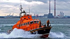 The Dun Laoghaire Trent Class Lifeboat Anna Livia out on exercise in Dublin Bay, with the red and white Poolbeg towers behind her.