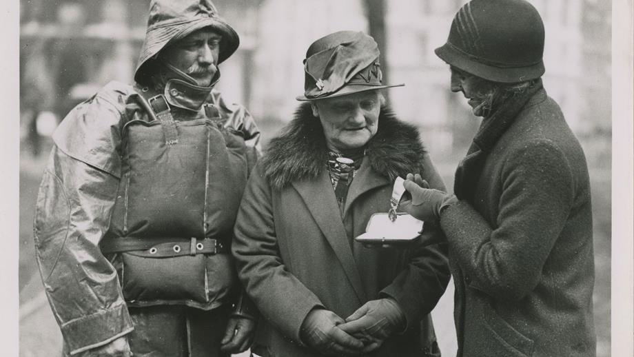Black and white image of two women and one man with medals
