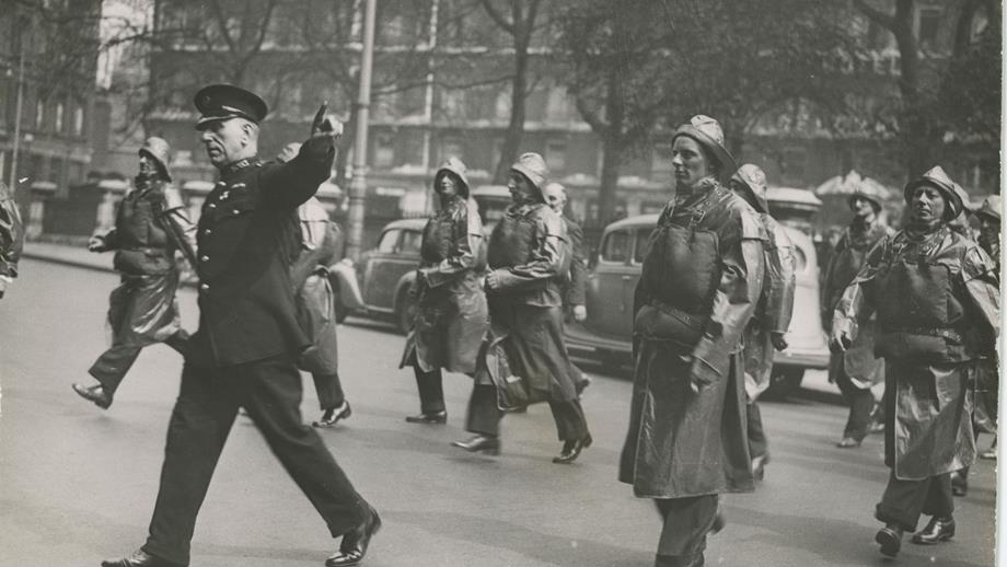 Black and white image of lifeboat crew crossing road in London
