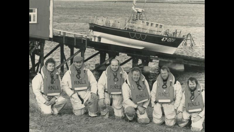Black and white image of six crew members with lifeboat on slipway