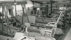 Black and white image of workshop interior with inflatable lifeboats being manufactured