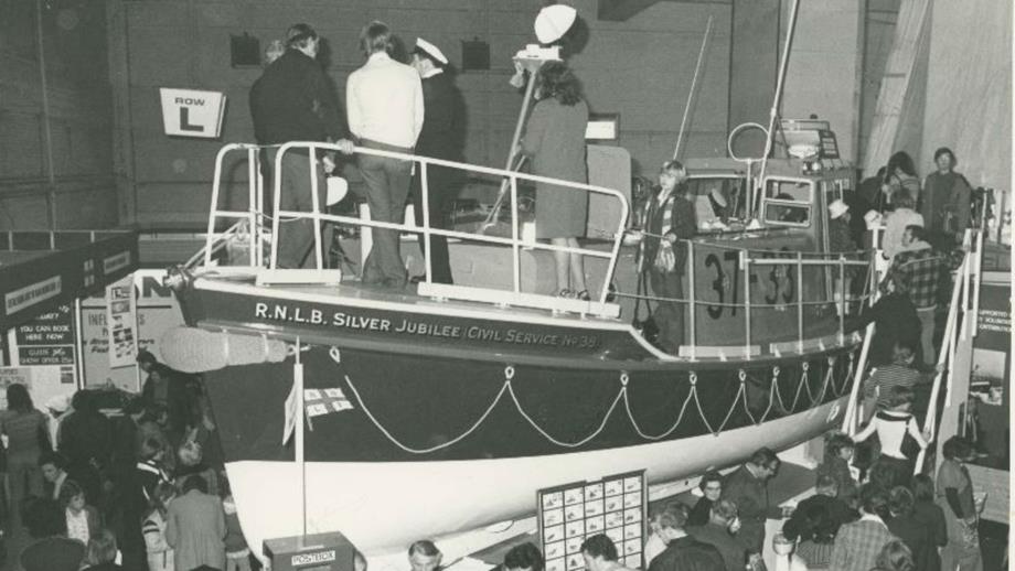 Black and white image of visitors to Boat Show viewing lifeboat