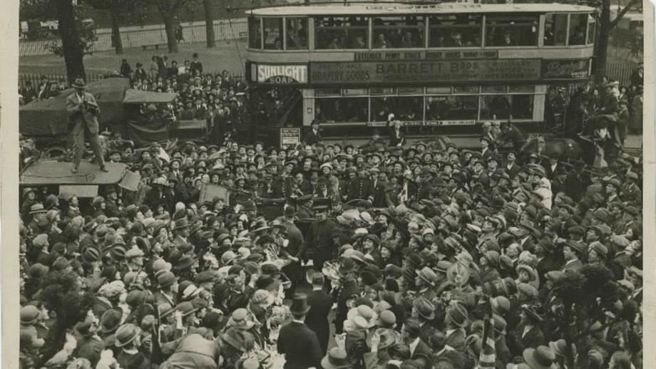 Black and white image of large crowd surrounding car of Prince of Wales