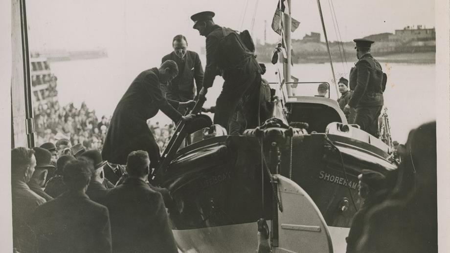 Black and white image of Prince George climbing into lifeboat at opening of Shoreham lifeboat station