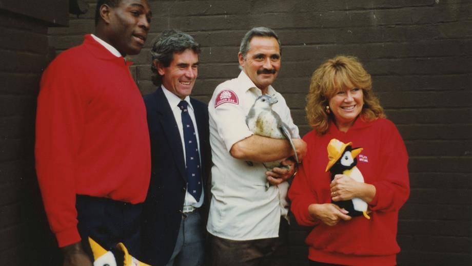 Colour image of group with live penguin and toy penguins