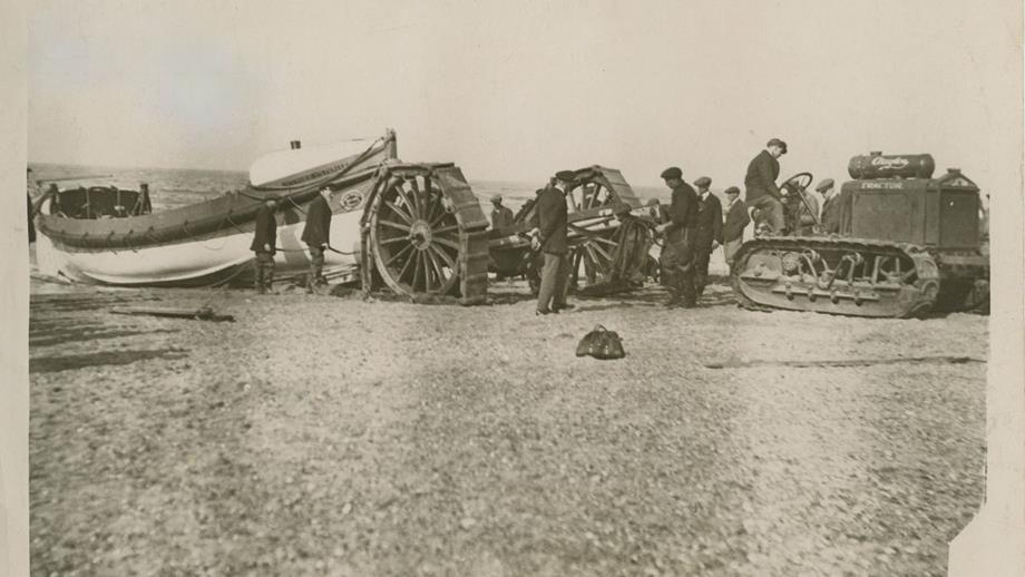Black and white image of lifeboat and tractor on beach