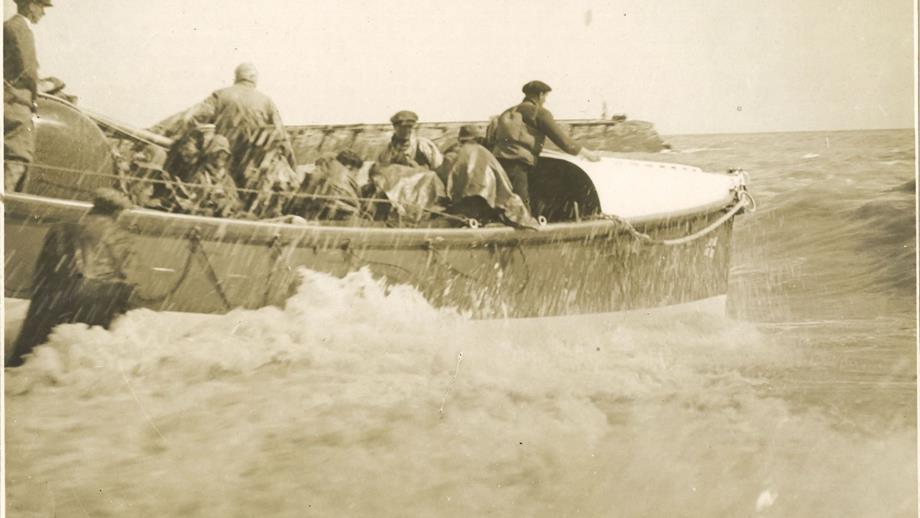 Black and white image of lifeboat launch from beach
