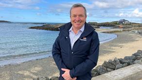 A man wearing an RNLI jacket stood in front of the sea