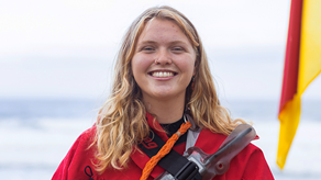 Portrait of RNLI lifeguard Rose McTavish with the sea in background