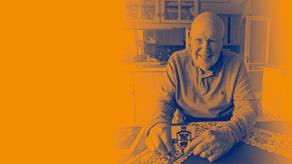 Stanley E Holtom sitting at a kitchen table and smiling at the camera