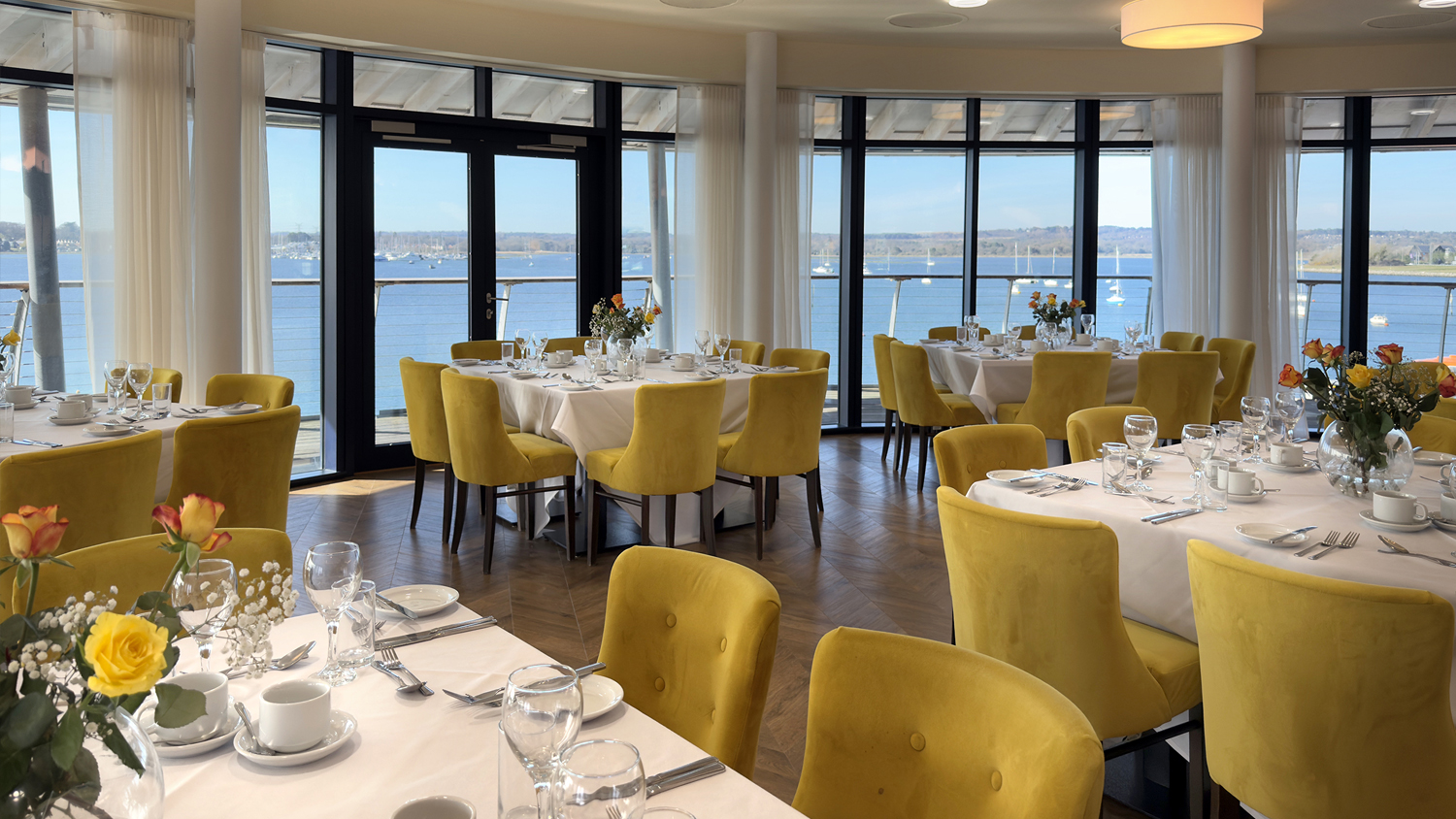 Photo of tables and chairs set up in the Harbour View room at the RNLI College