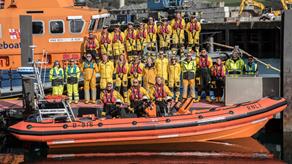 Group photo of Falmouth Lifeboat crew with Severn class all-weather lifeboat and Atlantic 85 inshore lifeboat