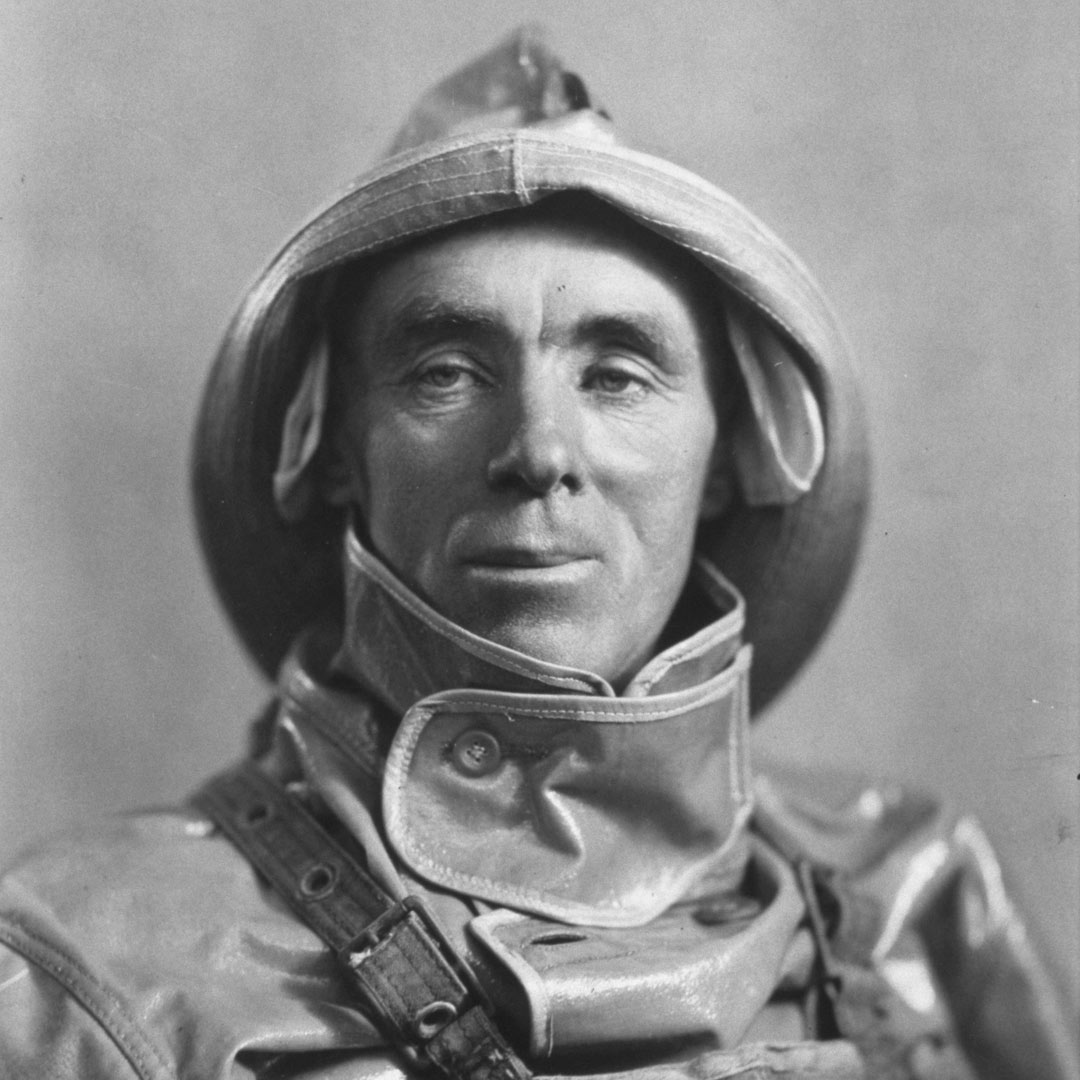 Black and white heritage portrait image of Ballycotton RNLI Coxswain Patrick Sliney wearing oilskins and a hat