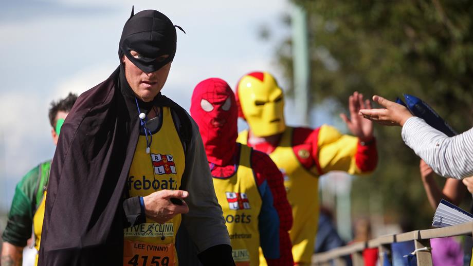 People dressed as superheroes including Batman and Spiderman wear RNLI running vests