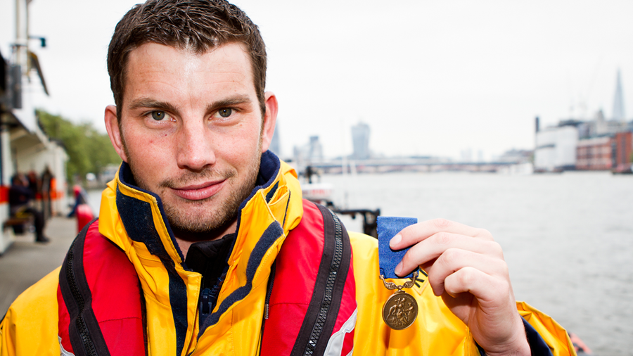 Porthcawl Lifeboat Station’s Chris Missen, holding up his Bronze Medal for Gallantry