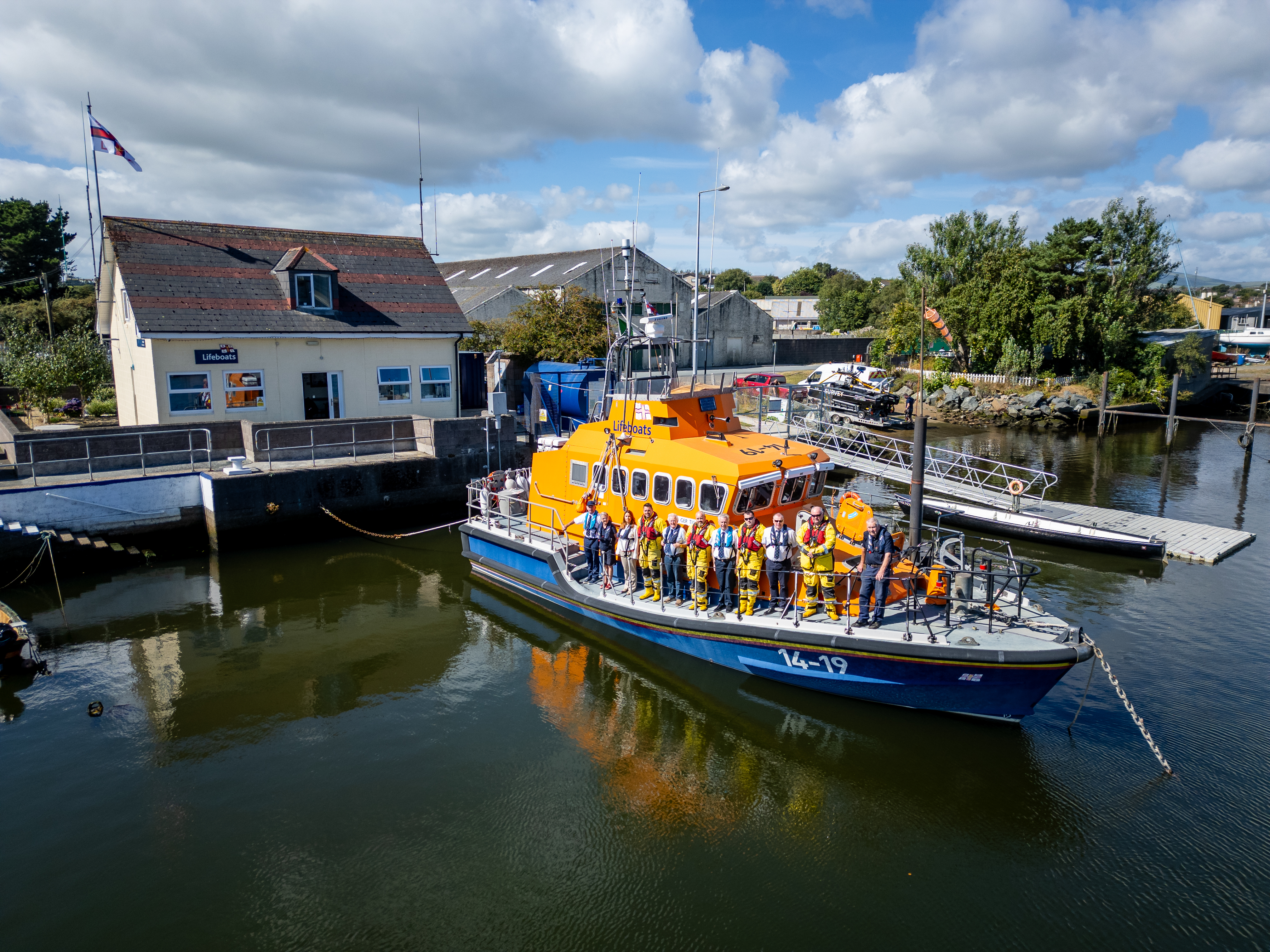 Arklow lifeboat crew members stand onboard a Trent class lifeboat as its moored in the harbour next to Arklow Lifeboat Station