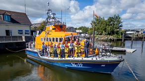 Image of Arklow's crew stood on the starboard side of their Trent lifeboat