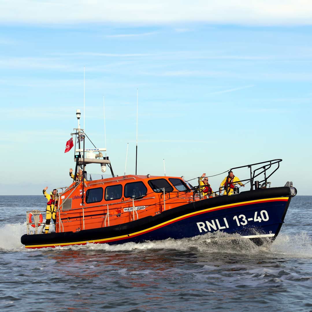 Eric's Legend lifeboat on a calm sea with clear blue sky.