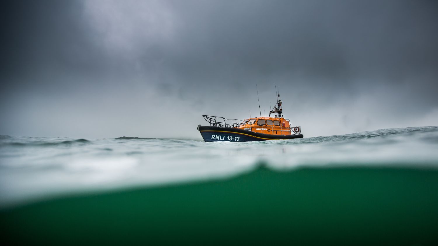 A Shannon class lifeboat from the water in front of a dark sky