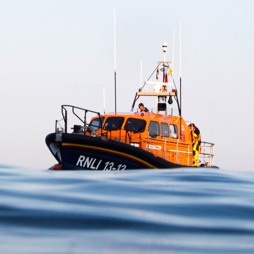 Swanage Launch a Memory Shannon class lifeboat George Thomas Lacy floats on calm seas under the orange glow of sunset