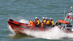 Four people riding a D class lifeboat at sea