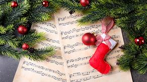 Pages of music notes with a Christmas wreath and red baubles.