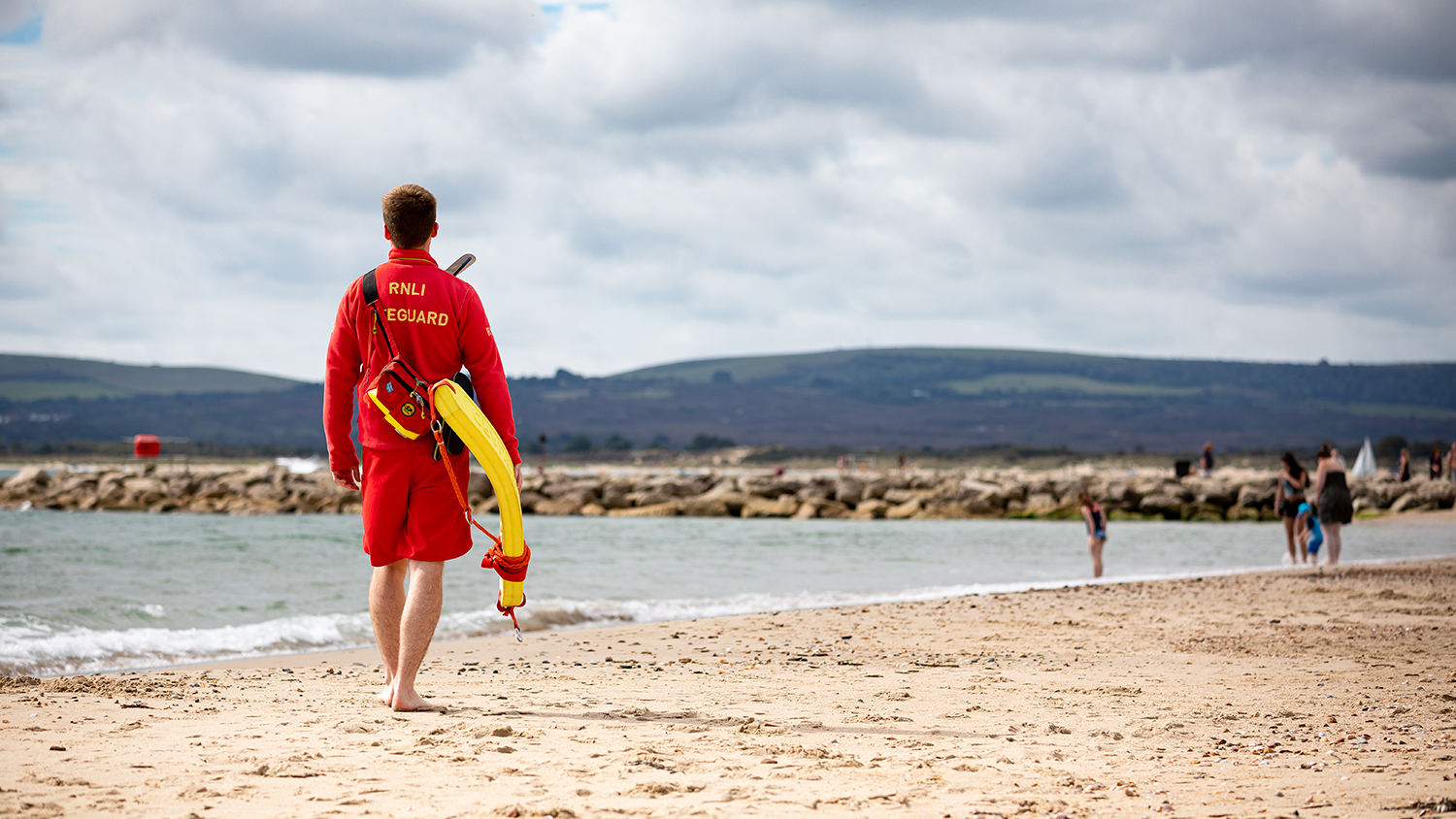 RNLI lifeguard patrolling water's edge
