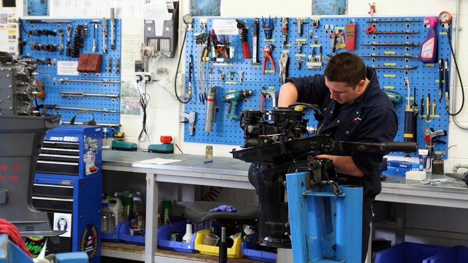Mechanic working on an outboard engine at the Inshore Lifeboat Centre