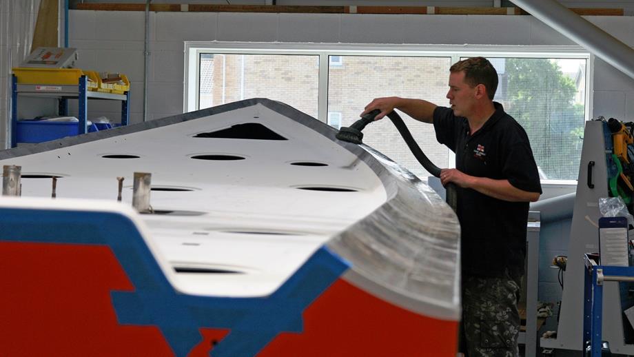 Engineer working on the hull of an inshore B class Atlantic lifeboat at the Inshore Lifeboat Centre