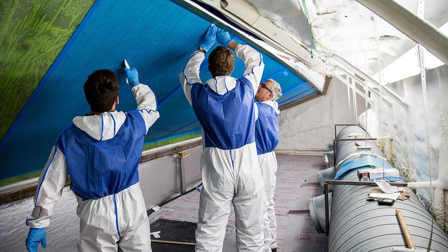 Boatbuilders working on the hull of a Shannon class lifeboat the at All-weather Lifeboat Centre