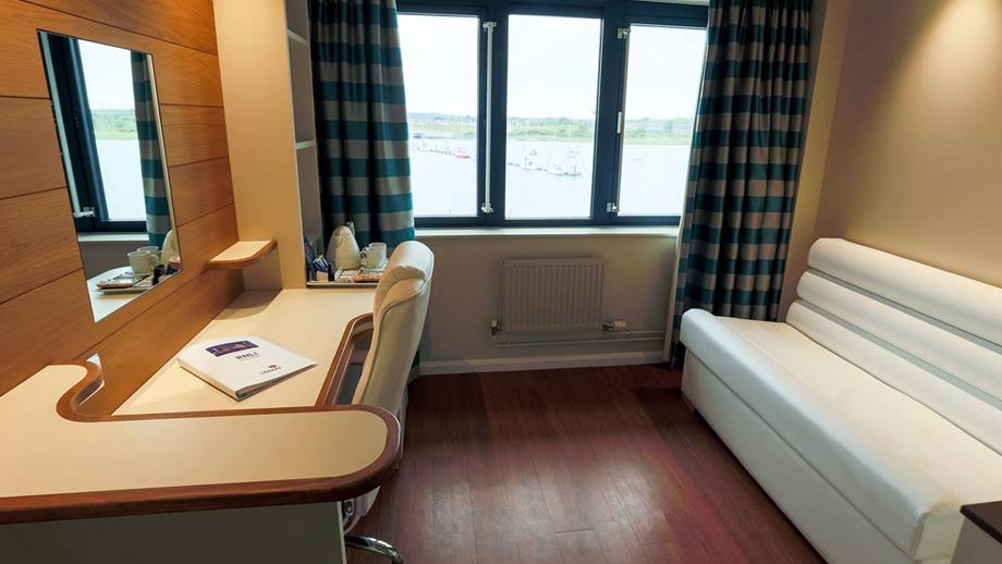 A bed and desk in a RNLI College hotel room